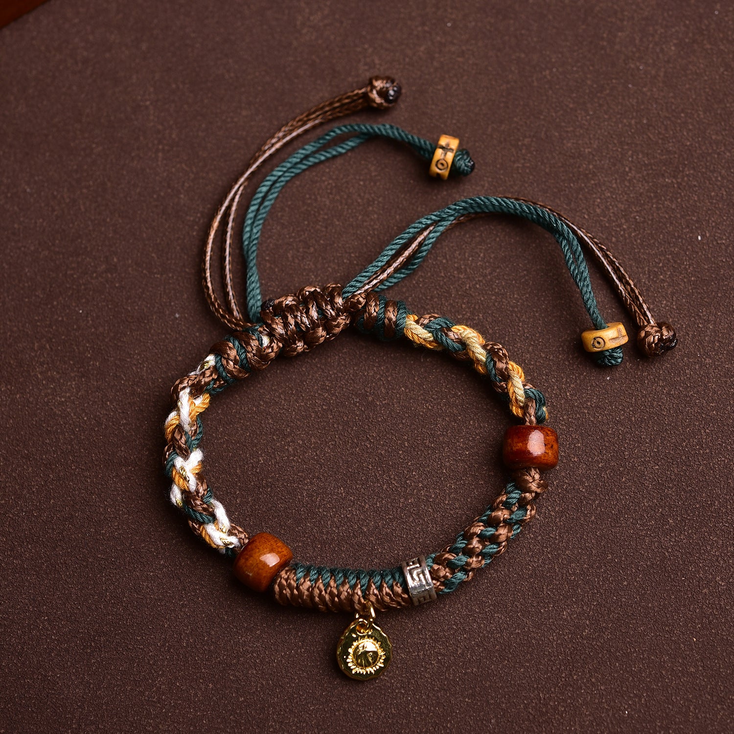 Bracelet with beads and charms on a brown background